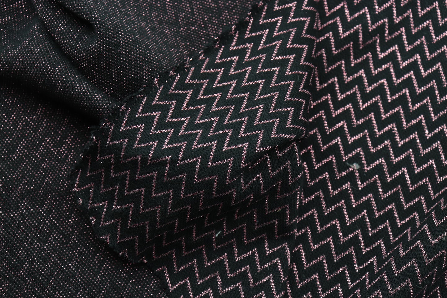 Two dark fabrics with rose gold geometric and flecked patterns.